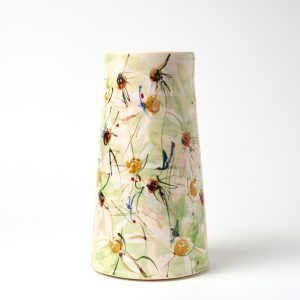 A photo of a ceramic vase with a hand painted floral design.
